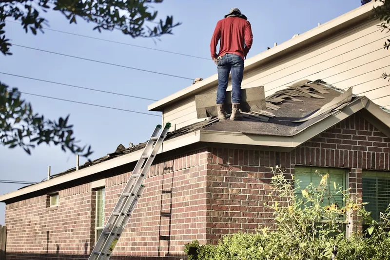 Professional roofer working on a residential roof in Woodport